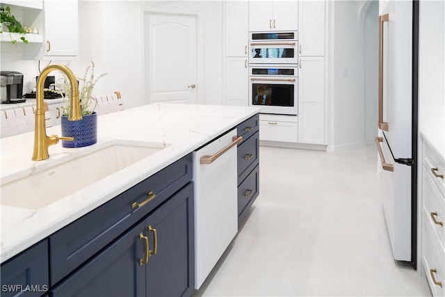 kitchen featuring white cabinetry, light tile patterned flooring, decorative backsplash, and white appliances