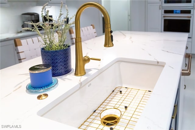 interior details featuring sink, decorative backsplash, and oven