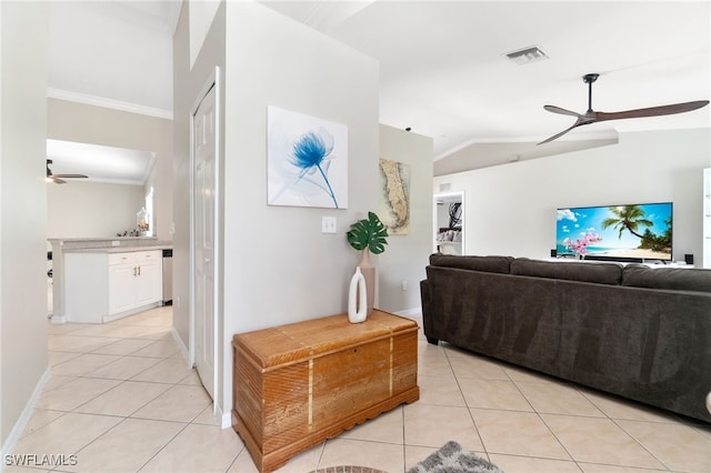 tiled living room featuring ornamental molding and vaulted ceiling