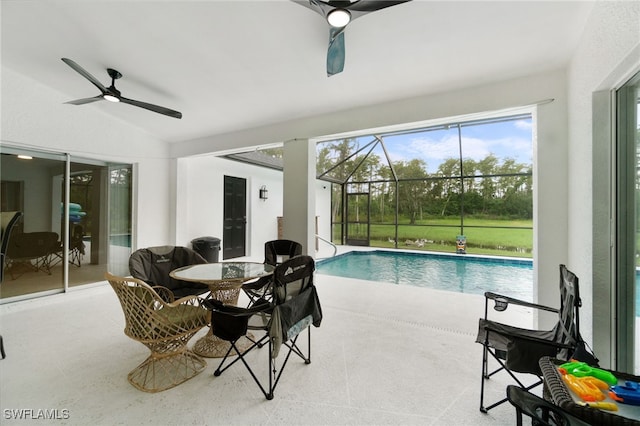 view of swimming pool featuring glass enclosure, ceiling fan, and a patio