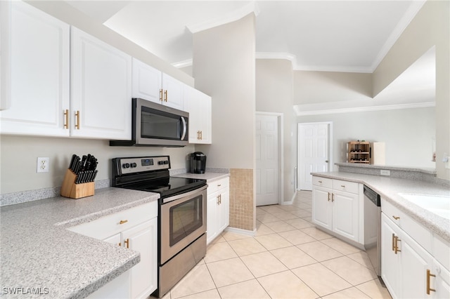 kitchen with white cabinets, ornamental molding, stainless steel appliances, and light tile patterned floors