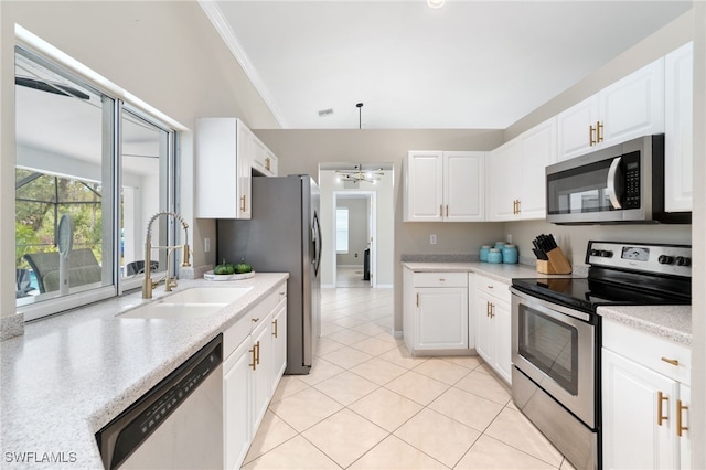 kitchen with sink, white cabinets, appliances with stainless steel finishes, light tile patterned floors, and crown molding