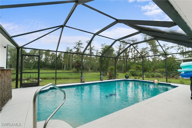 view of pool with glass enclosure, a yard, and a patio area