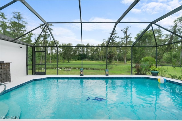 view of swimming pool with a lawn and a lanai