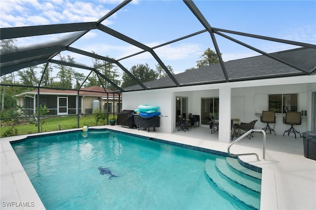 view of pool featuring area for grilling, glass enclosure, a patio area, and a lawn