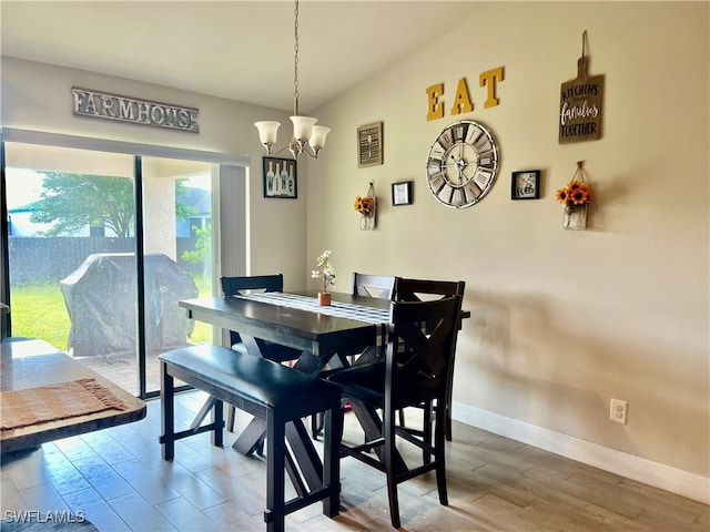 dining area with a wealth of natural light, a chandelier, and hardwood / wood-style flooring