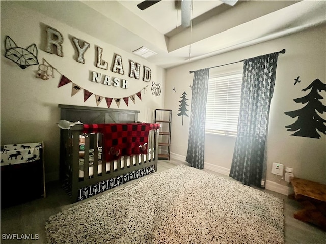 bedroom with ceiling fan, wood-type flooring, and a crib