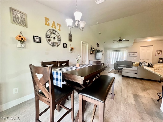 dining room with lofted ceiling, ceiling fan with notable chandelier, and light wood-type flooring