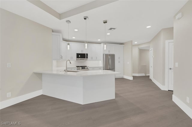 kitchen featuring dark wood-type flooring, white cabinetry, appliances with stainless steel finishes, and decorative light fixtures