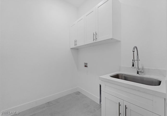 washroom with cabinets, light tile patterned floors, sink, and washer hookup