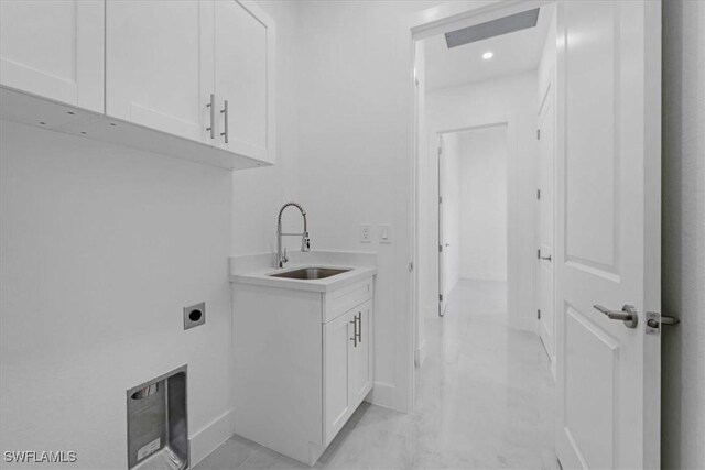 laundry area featuring electric dryer hookup, sink, light tile patterned flooring, and cabinets