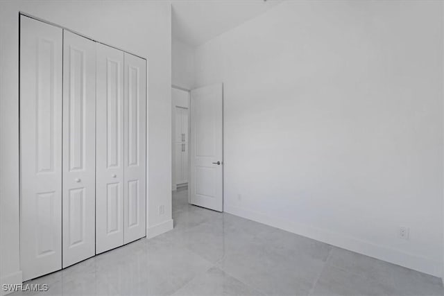 unfurnished bedroom with a closet and light tile patterned floors