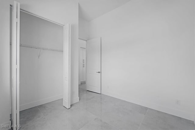 unfurnished bedroom with light tile patterned flooring and a closet