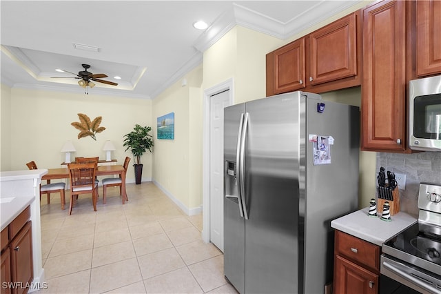 kitchen featuring stainless steel appliances, light tile patterned floors, ceiling fan, tasteful backsplash, and a raised ceiling