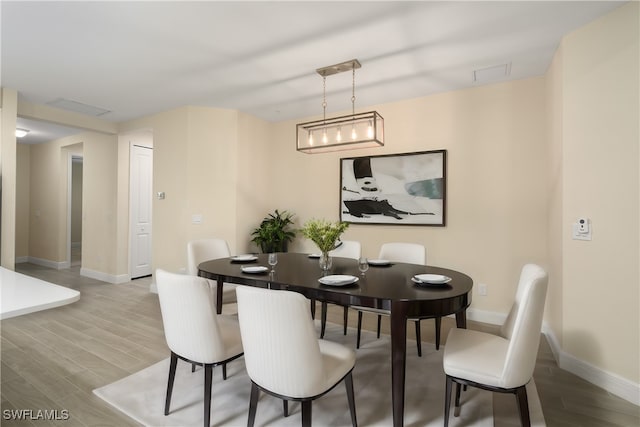 dining room with a notable chandelier and light hardwood / wood-style flooring