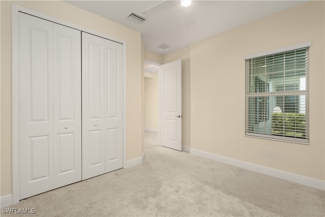 unfurnished bedroom with carpet, a closet, and ceiling fan