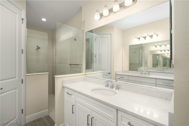 bathroom with a tile shower and vanity