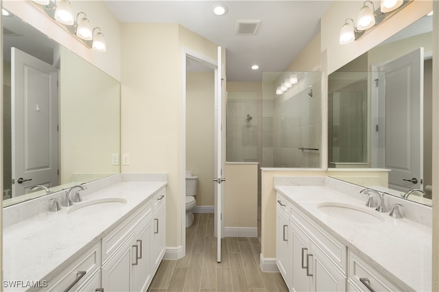 bathroom featuring tile patterned floors, vanity, tiled shower, and toilet