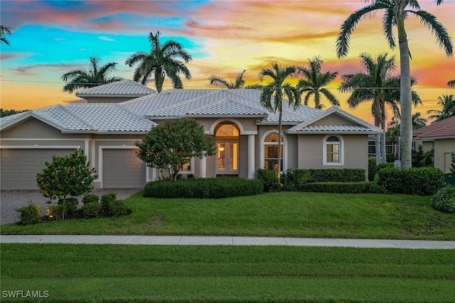 view of front of home featuring a lawn and a garage