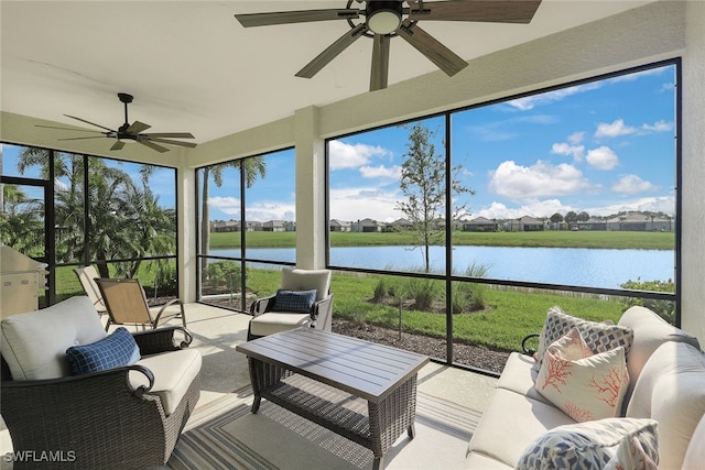 sunroom with ceiling fan and a water view