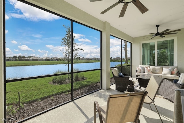 sunroom / solarium with ceiling fan and a water view