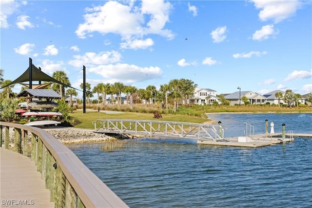 view of dock featuring a lawn and a water view