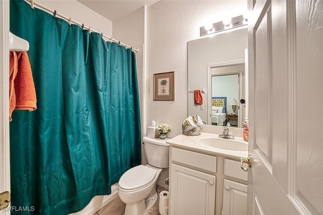 bathroom with vanity, tile patterned flooring, toilet, and walk in shower