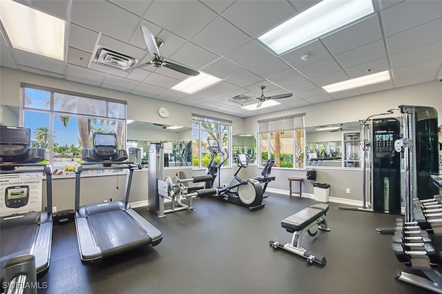 exercise room with ceiling fan and a drop ceiling