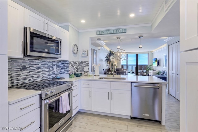 kitchen featuring crown molding, stainless steel appliances, sink, backsplash, and kitchen peninsula