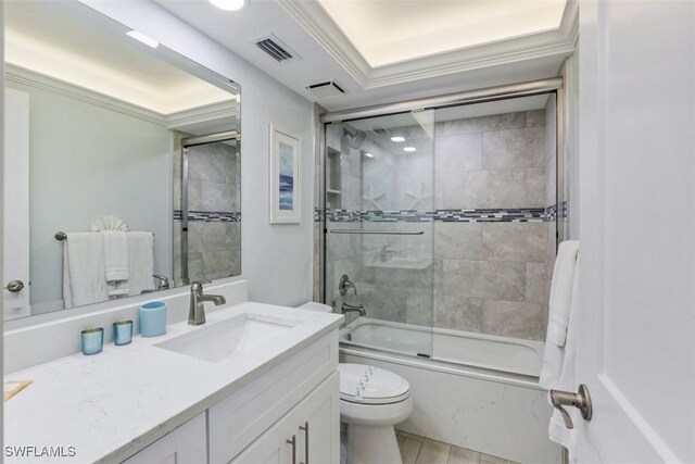 full bathroom with combined bath / shower with glass door, toilet, vanity, ornamental molding, and a tray ceiling