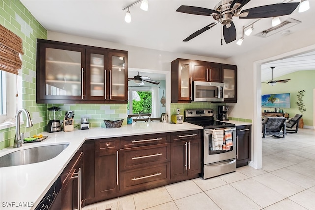 kitchen with light tile patterned floors, sink, dark brown cabinets, backsplash, and stainless steel appliances