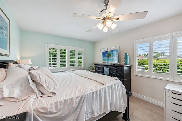 tiled bedroom featuring multiple windows and ceiling fan