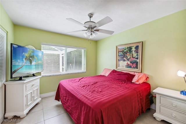 tiled bedroom featuring ceiling fan