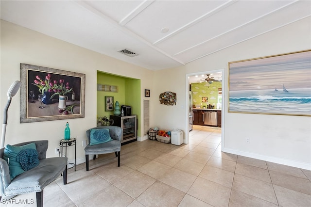 sitting room with light tile patterned flooring, vaulted ceiling, and beverage cooler