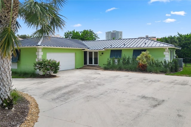 ranch-style house with a garage and central AC