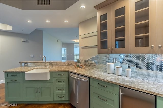 kitchen with visible vents, a sink, light stone counters, green cabinets, and dishwasher