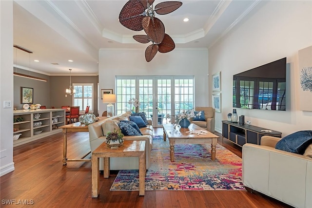 living room featuring a tray ceiling, crown molding, wood finished floors, and french doors