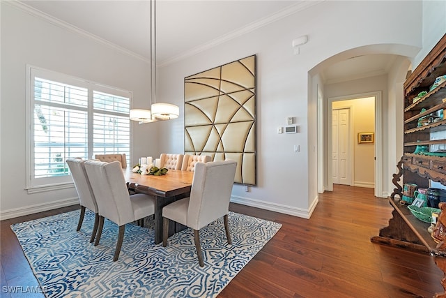 dining space featuring dark wood-type flooring and crown molding