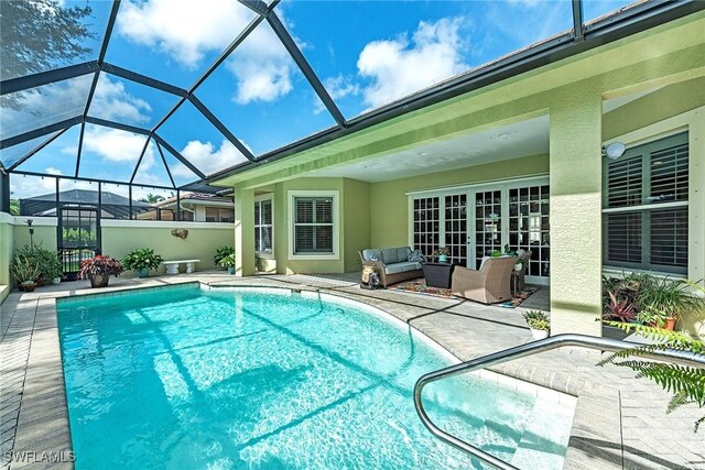 outdoor pool featuring glass enclosure, an outdoor hangout area, and a patio