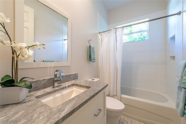 full bathroom featuring shower / bath combo with shower curtain, toilet, and vanity
