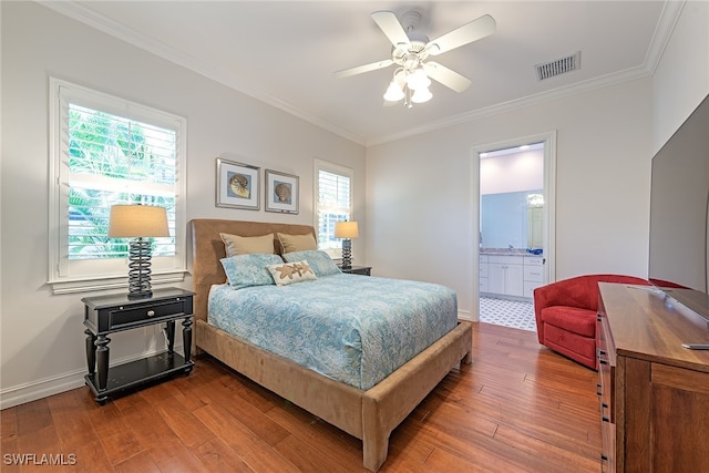 bedroom featuring dark wood-type flooring, ceiling fan, ensuite bath, and ornamental molding