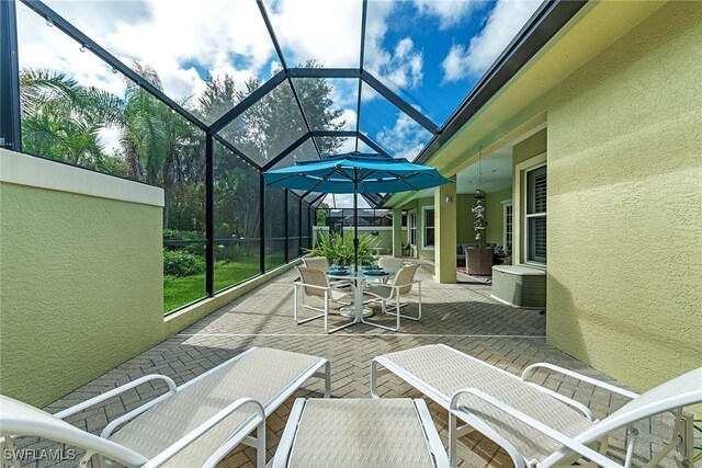 view of patio featuring glass enclosure and outdoor dining area