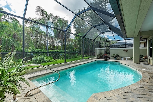 view of pool with a patio and glass enclosure