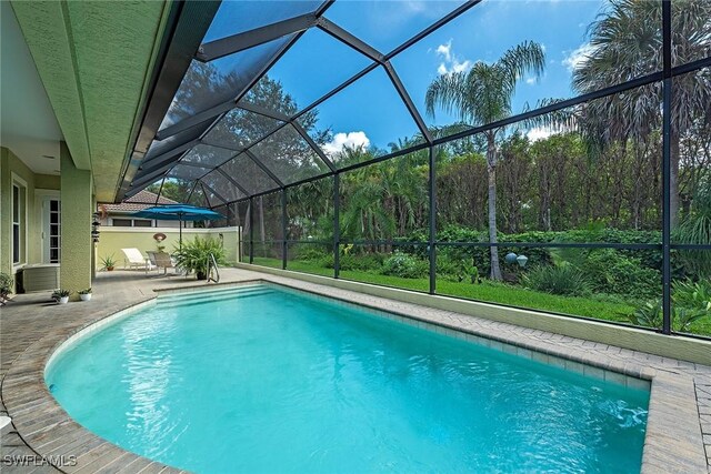 pool with a patio area and glass enclosure