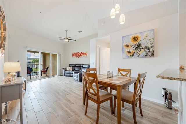 dining area with light hardwood / wood-style flooring and ceiling fan with notable chandelier