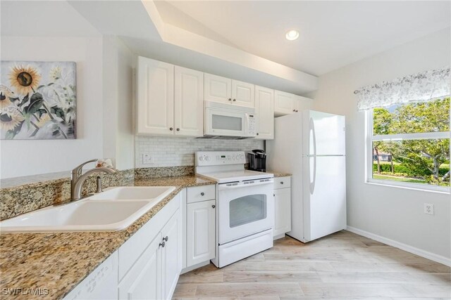 kitchen featuring tasteful backsplash, white appliances, light hardwood / wood-style floors, white cabinetry, and sink