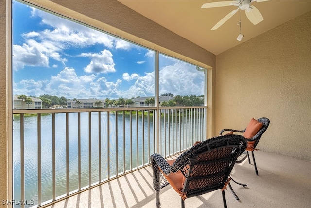 balcony with ceiling fan and a water view