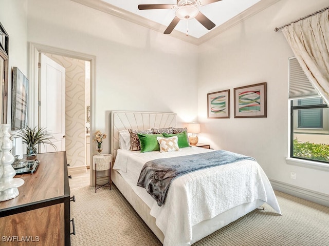 bedroom with ornamental molding, light colored carpet, a ceiling fan, and baseboards