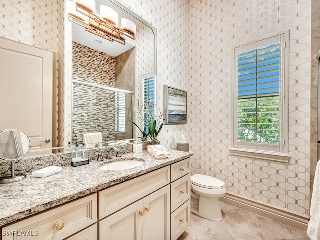 full bathroom featuring a stall shower, vanity, and toilet