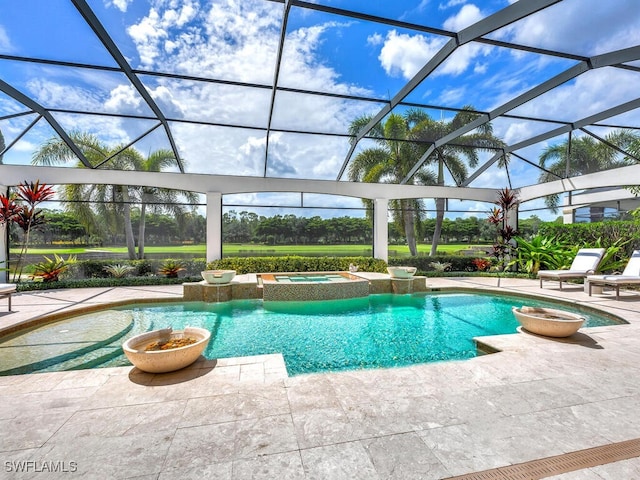 view of pool with a pool with connected hot tub, glass enclosure, and a patio